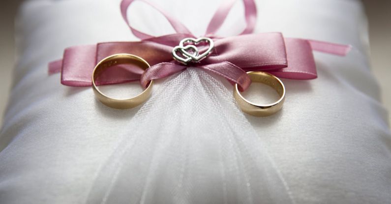 Engagement - Selective Focus Photography of Silver-colored Engagement Ring Set With Pink Bow Accent on Throw Pillow