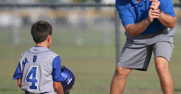 Coach - Man Kneeling on Baseball Field Beside Man