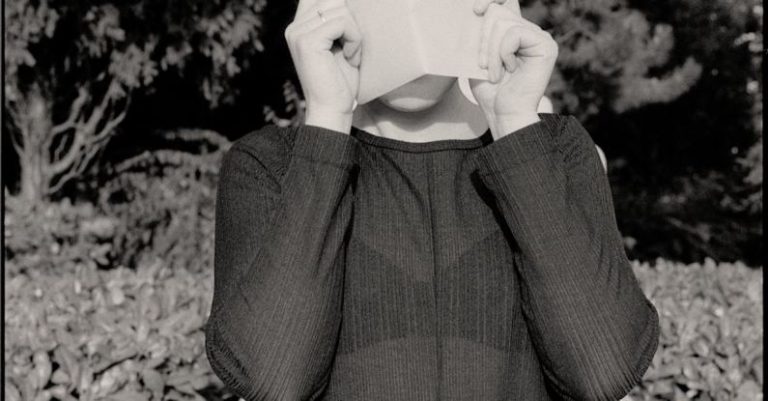 Curriculum - Woman Covering Face with Curriculum Vitae against Sculpture