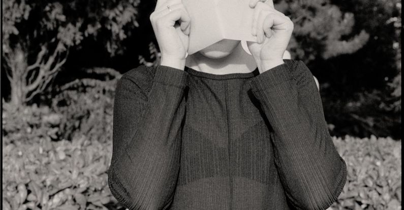 Curriculum - Woman Covering Face with Curriculum Vitae against Sculpture