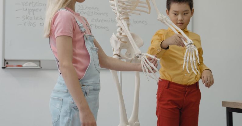 Learning - Student standing beside a Skeleton Model