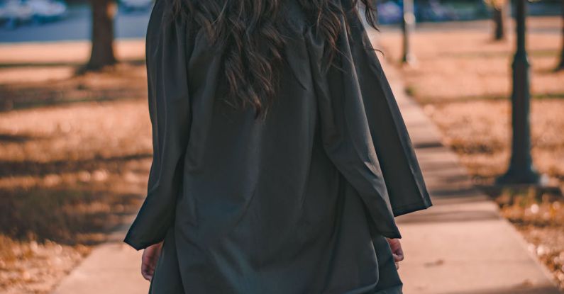 Degrees - Woman in Black Long Sleeve Dress Standing on Brown Concrete Pathway