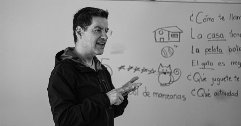 Teaching Challenges - A man standing in front of a whiteboard with a black and white photo